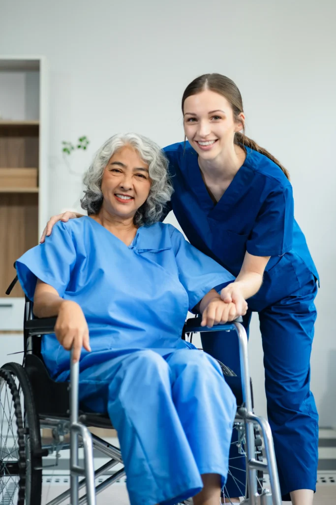 Nurse supporting smiling elderly woman wheelchair.
