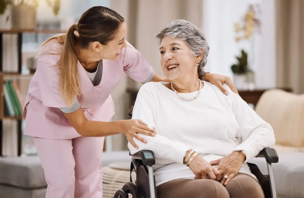 Nurse supporting happy senior woman wheelchair.