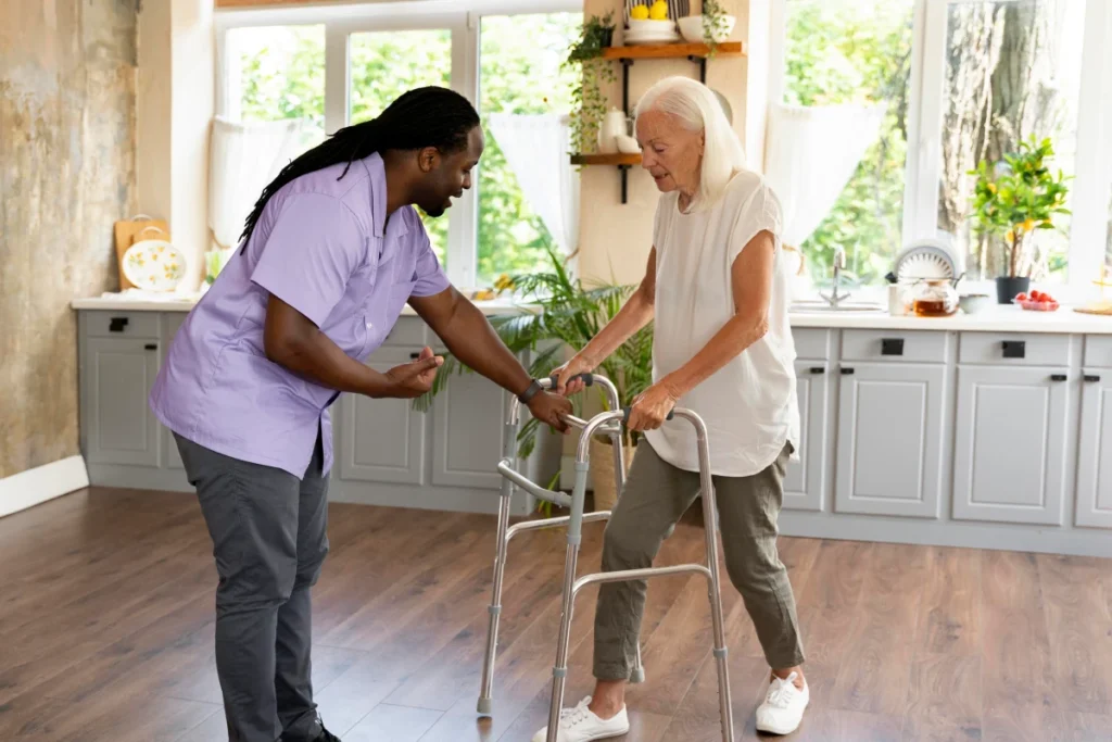 Caregiver supporting senior woman using walker.