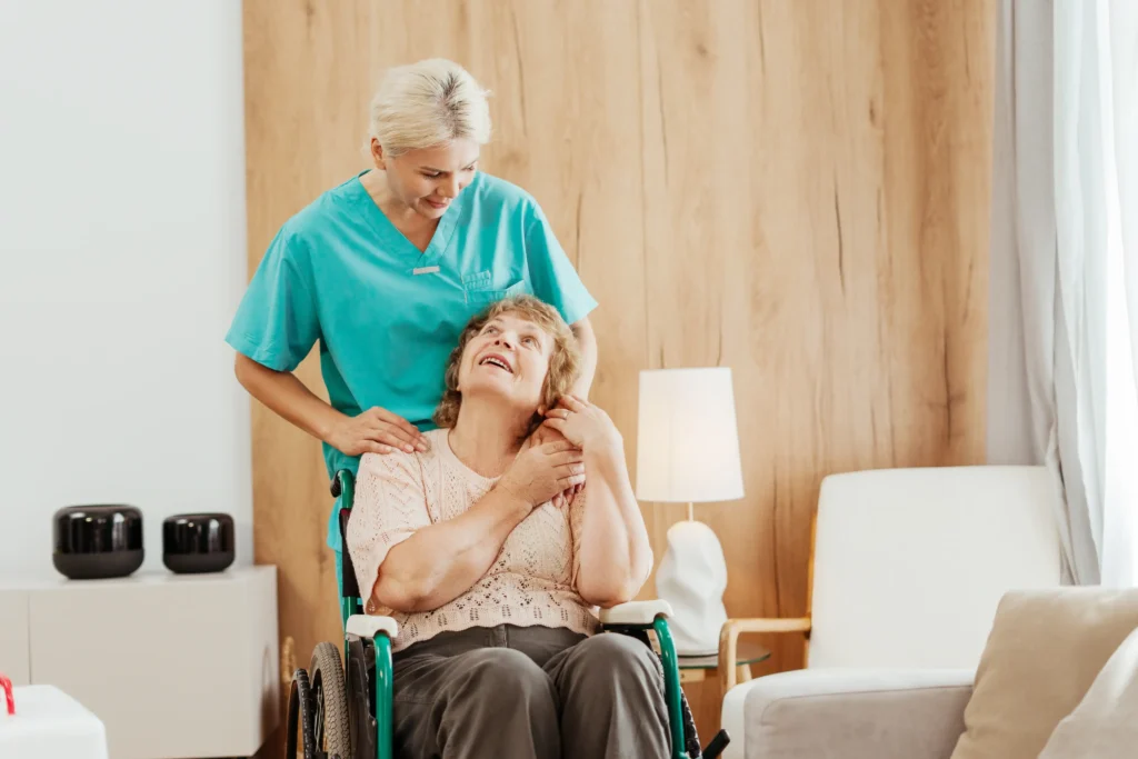 Caregiver comforting smiling elderly woman in wheelchair.