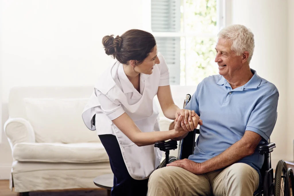 Caregiver assisting smiling elderly man wheelchair.