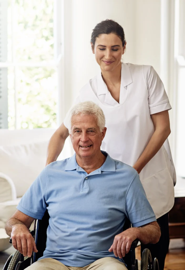 Caregiver assisting smiling elderly man wheelchair.