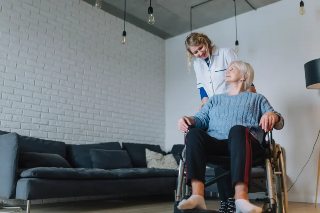 Caregiver assisting elderly woman in wheelchair.