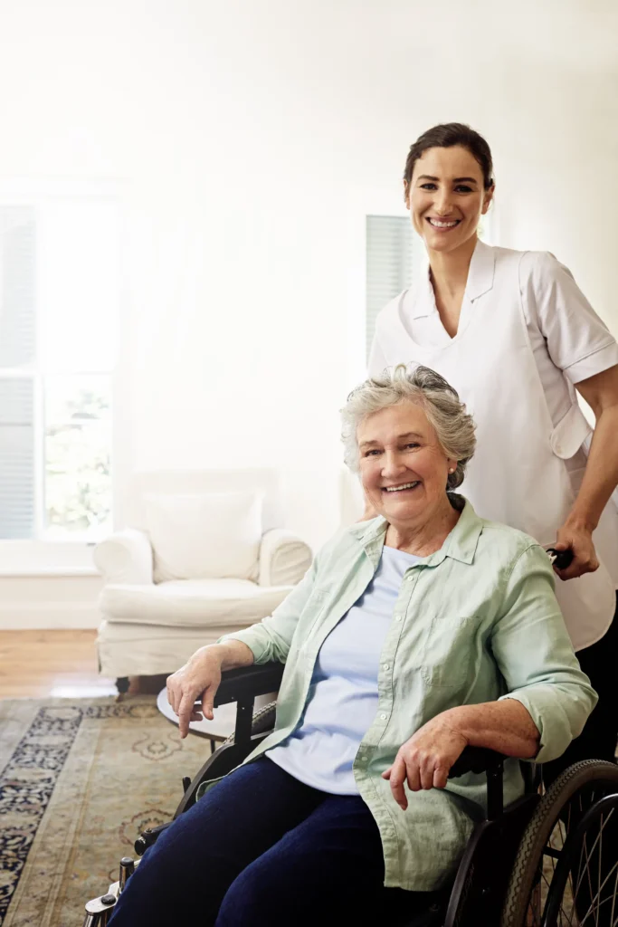 Caregiver smiling with elderly woman wheelchair.